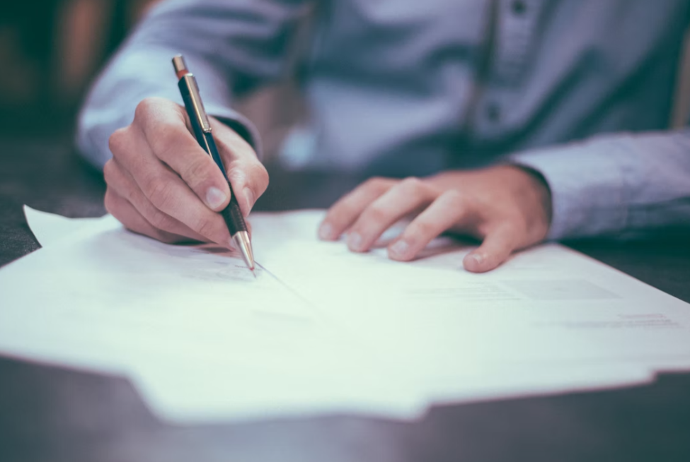 종이에 만년필로 종부세를 계산해보고 있는 남자의 손