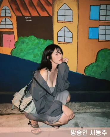 서동주가 회색톤 옷을 입고 쪼그려 앉아있는 사진