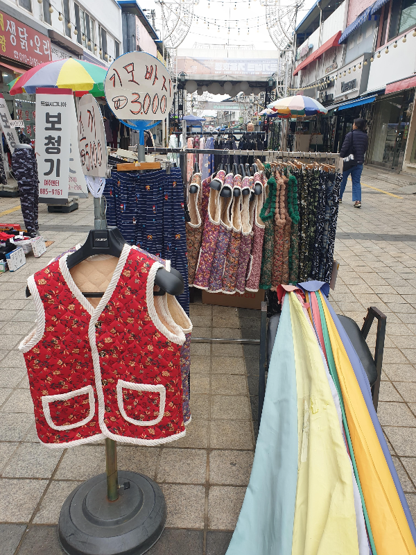 시장 길 한복판 옷을 헹어에 걸어놓고 판매하고 있다.