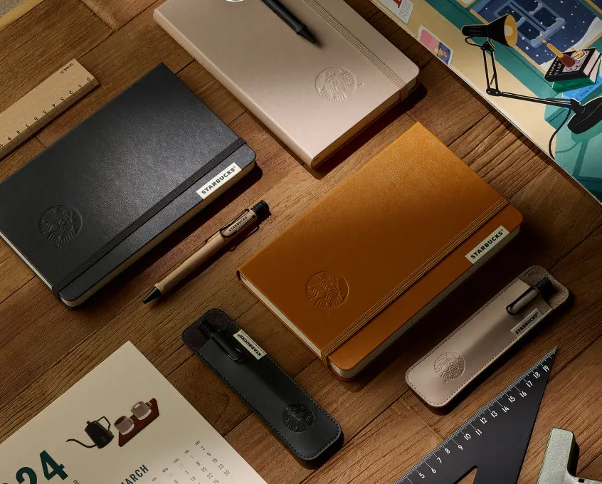 스타벅스-다이어리가-책상위에-펜들과-함께-놓여있는-사진