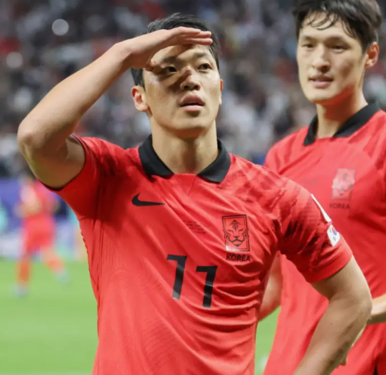 붉은 유니폼 오른손으로 햇빛을 가리는 황희찬