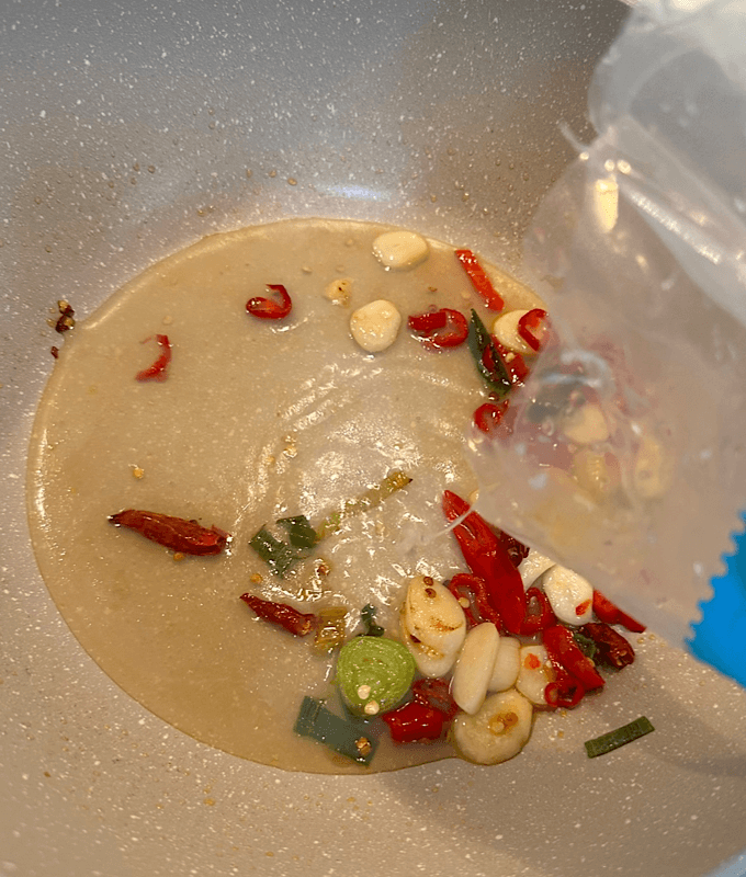 팬에 마늘, 고추 볶는 중 소스가 들어가는 장면