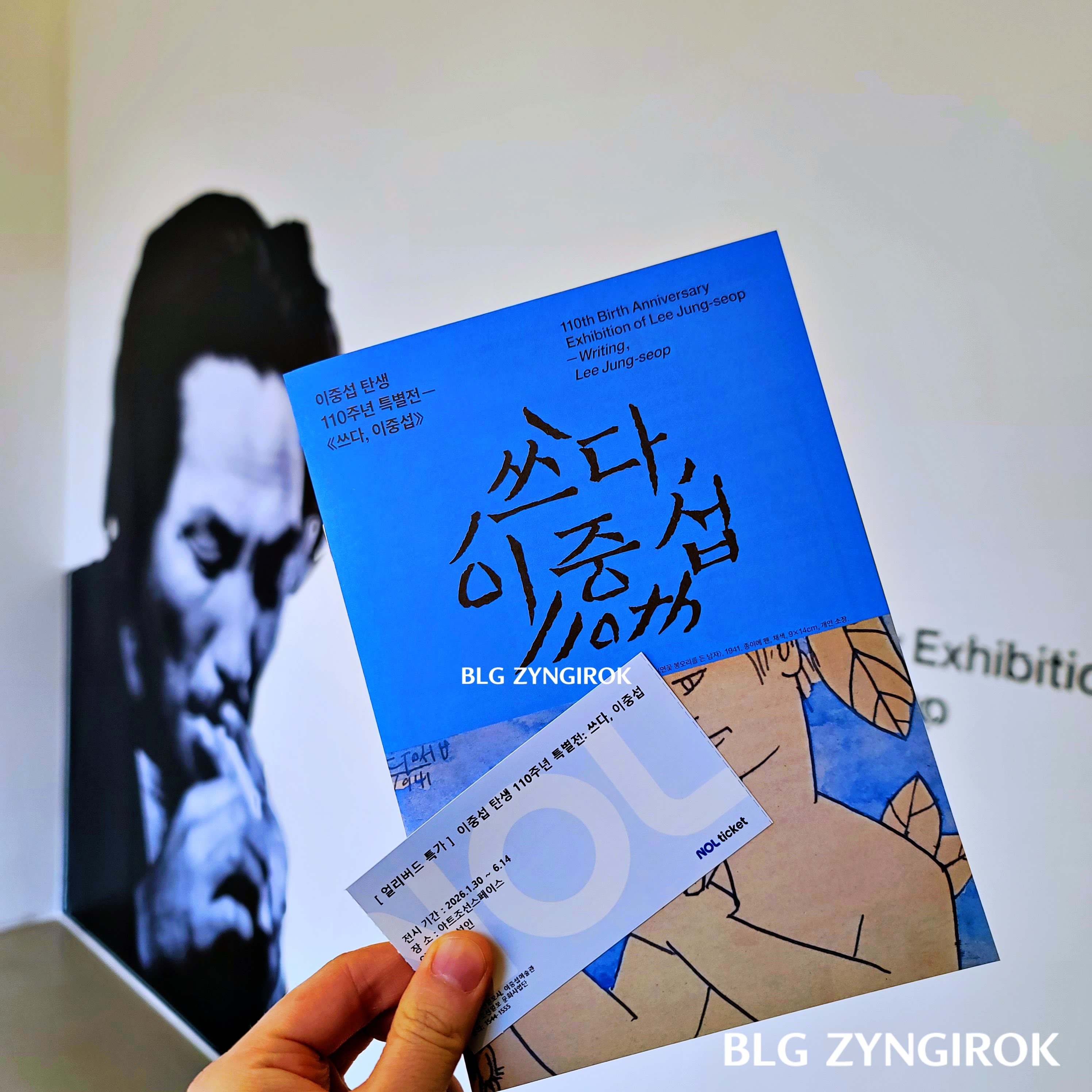 쓰다 이중섭 - 안내 책자와 티켓을 들고있다.