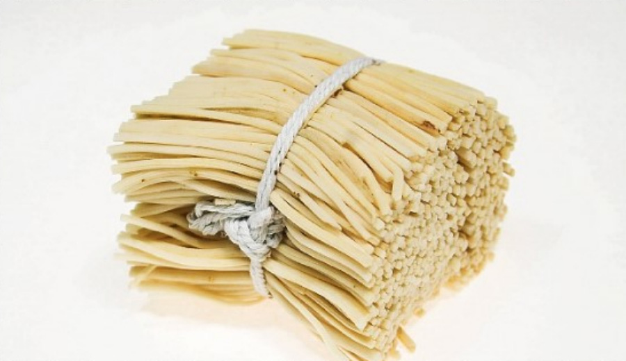 야생에서 채취를 한 골풀의 줄기를 잘 세척한 후에 손질을 한 것을 한다발 끈으로 묶은 후에 하얀 바닥 위에 놓아두고 찍은 사진