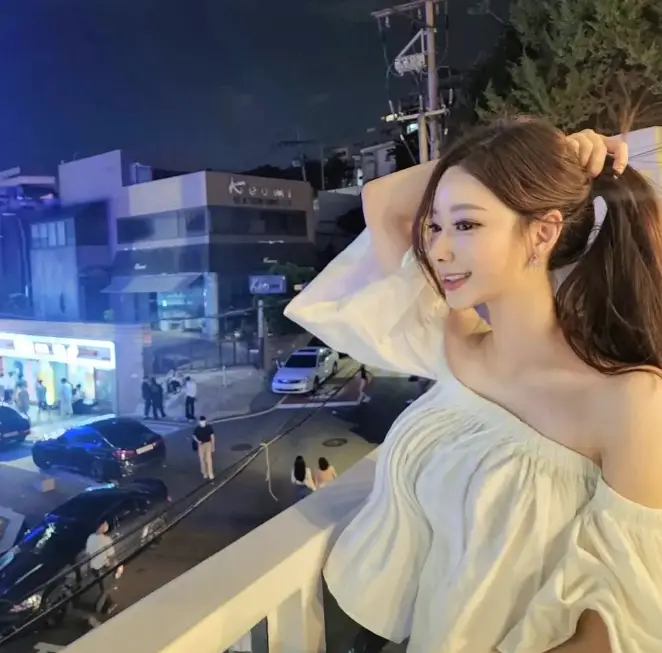 솔로지옥 3 - 어깨가 드러나는 반팔티에 오른손을 뒤로하여 머리카락 전체를 하나로 잡고 앉아서 외부를 바라보고 있는 안민영 왼쪽 모습