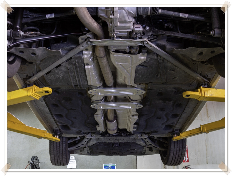 자동차 리프트 위에서 점검 중인 미니 클럽맨 하체 사진