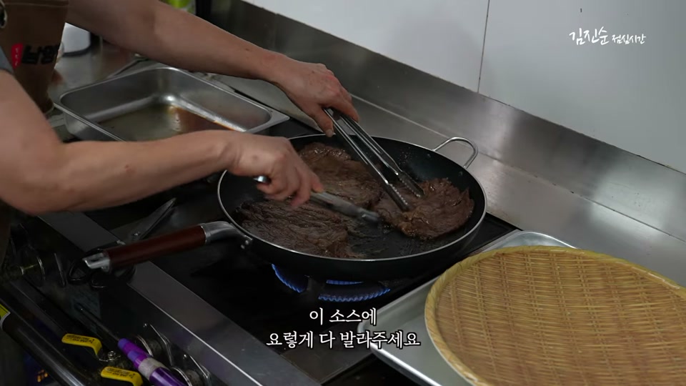 구운 고기에 양념소스를 발라 윤기를 내는 장면