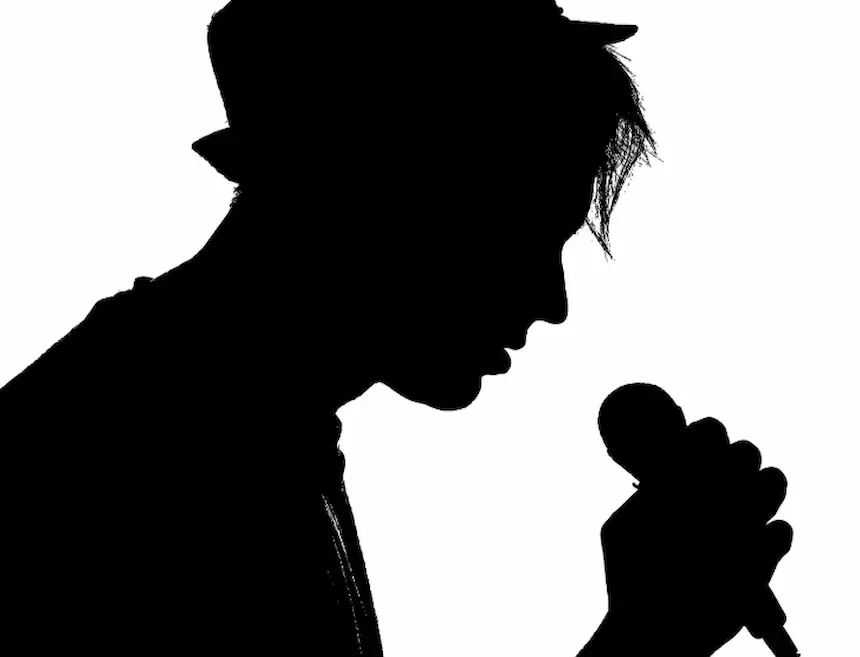 마이크를 쥐고 모자를 쓴 남자의 옆모습 실루엣