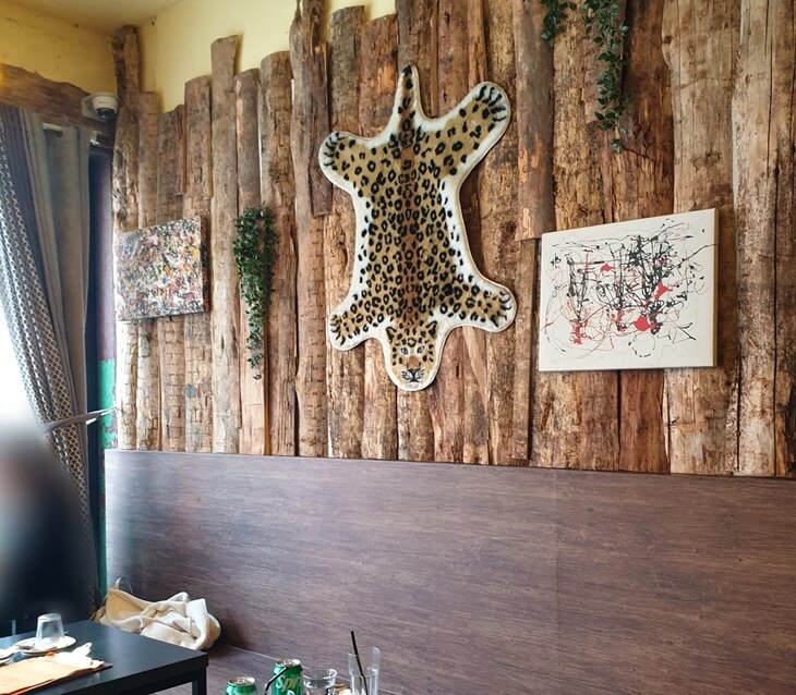 서울숲역화덕피자맛집-누메로뜨레스-내부-벽에는-호랑이일러스트러그와-다양한-그림이-나무벽에-걸려있다