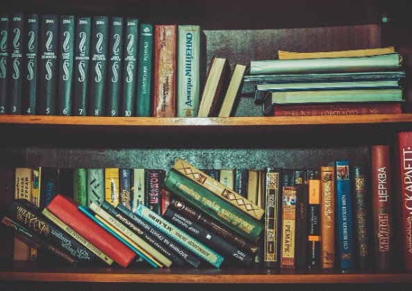 책꽂이에 많은 책이 꽂혀있는 사진