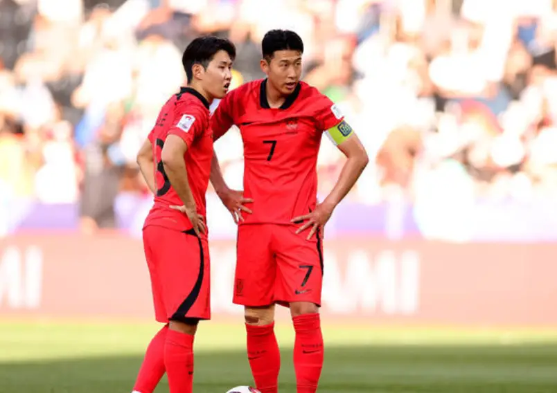 사우디아라비아전- 초록 그라운드 좌측 이강인과 우측 손흥민인 붉은 반팔유니폼을 입고 서서 대화하고 있는 모습