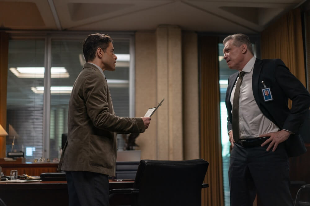 영화 아마추어 스틸컷 – 사무실에서 남자 주인공이 상사와 서류를 두고 맞서는 장면