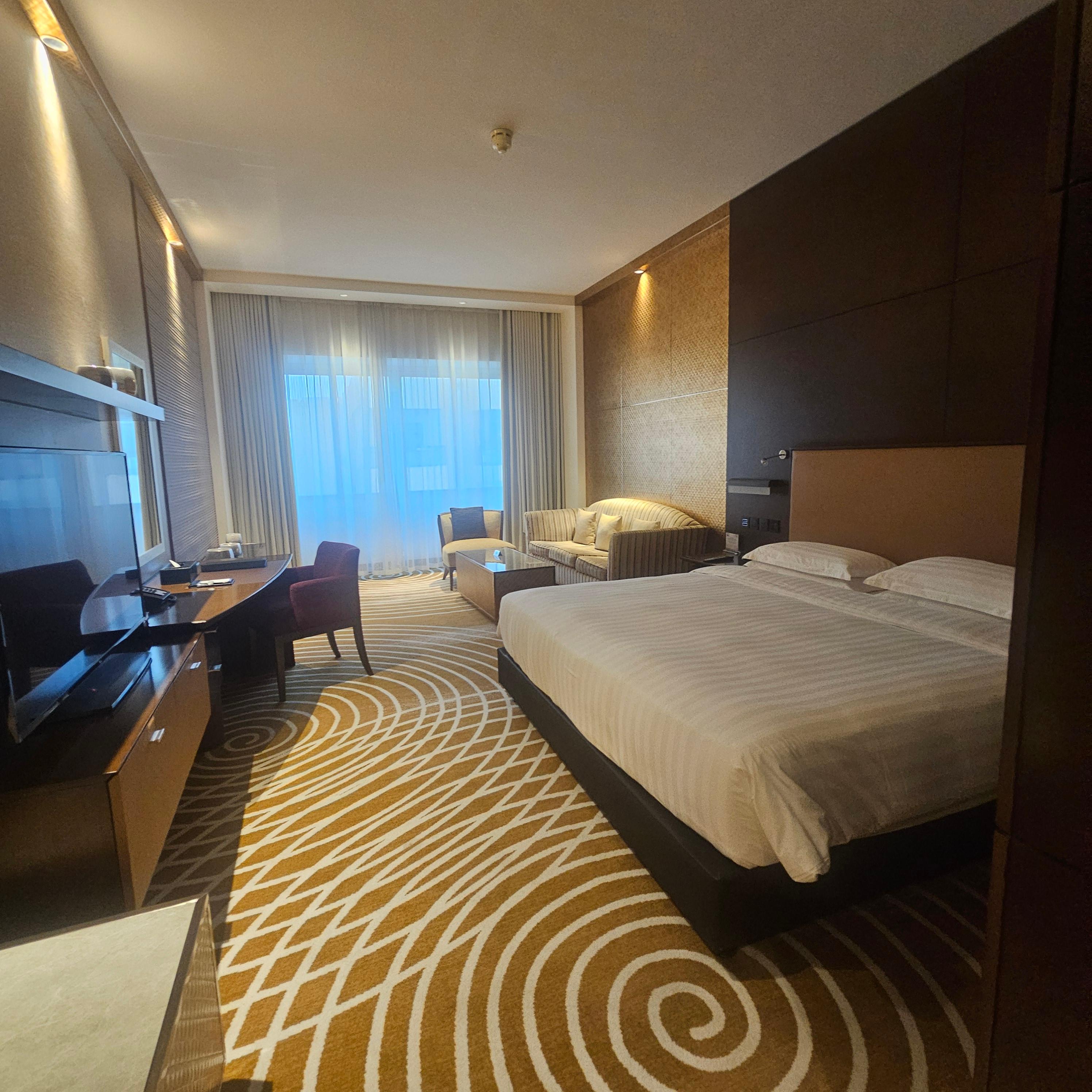 두바이 아시아나 호텔 객실 내부 침대와 소파 그리고 책상