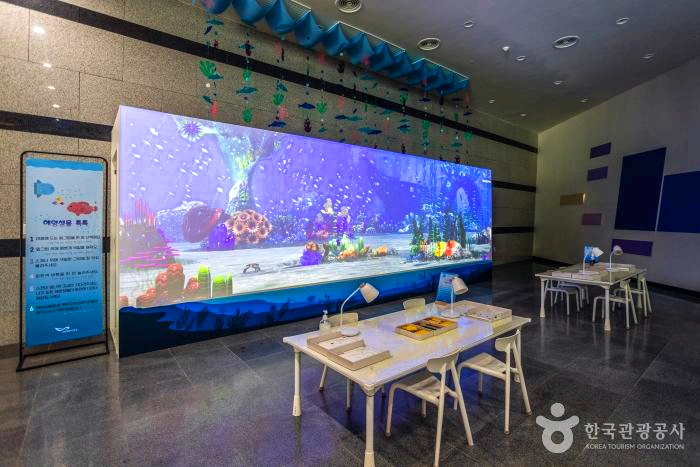 건물내부에 대형 스크린과 책상 의자들이 있다.