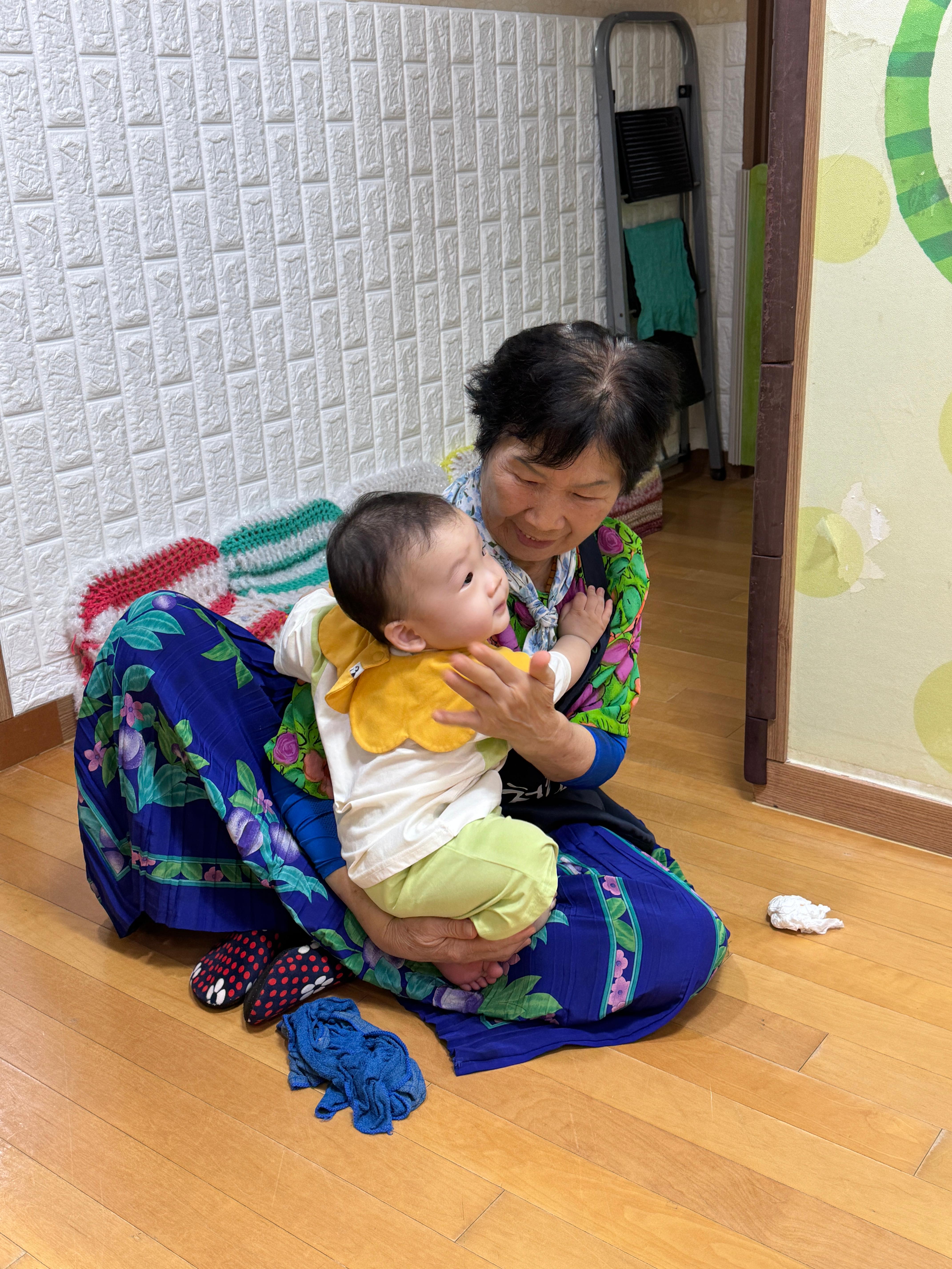 어린이집 도우미 할머님께 안겨있는 11개월 아기