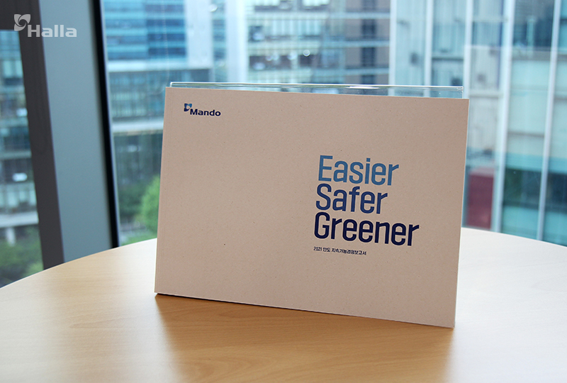 원형 나무 테이블 위에 올려져 있는 만도 2021 지속가능경영보고서 이미지