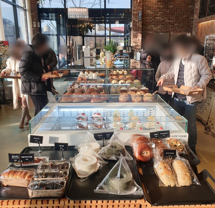 숲속의제빵소에서-사람들이-빵을-고르고-있다