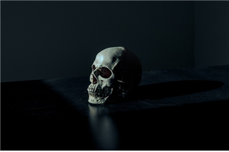 어두운 공간 어두운 책상 위 해골 하나 사진