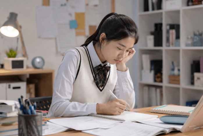 책상에 앉아 공부에 집중하는 여학생