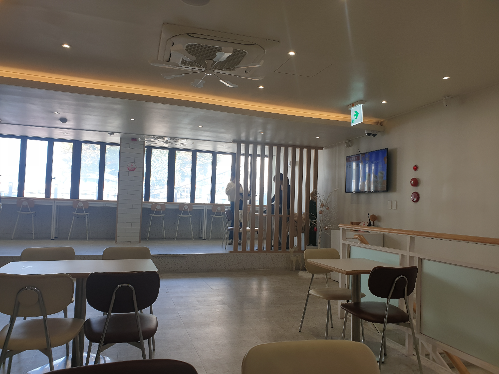 2층 우드 파티션 뒤쪽 서 있는 두 명의 사람이 보인다.