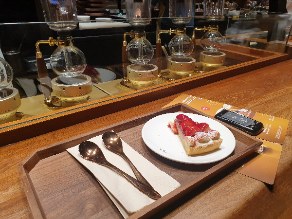 조각 케익과 스푼 2개 그리고 진동벨이 보인다.