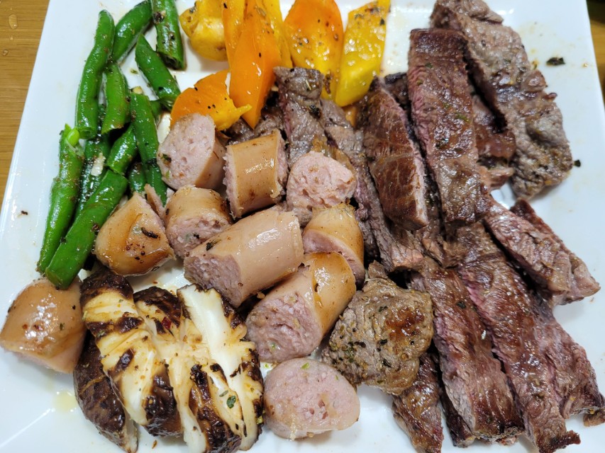 썰어 놓은 부채살 스테이크와 소시지 야채