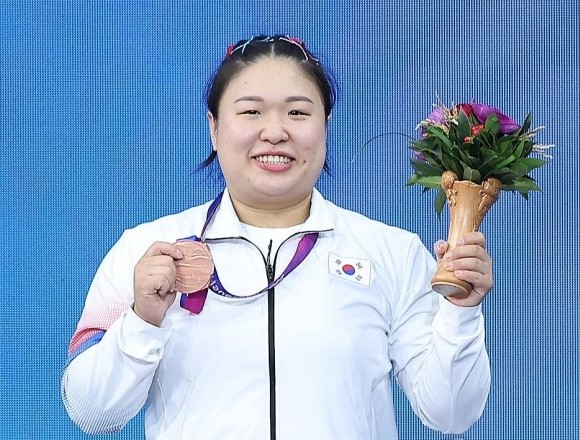 동메달을 목에 걸고 한손에는 꽃다발을 들고 있는 김수현선수