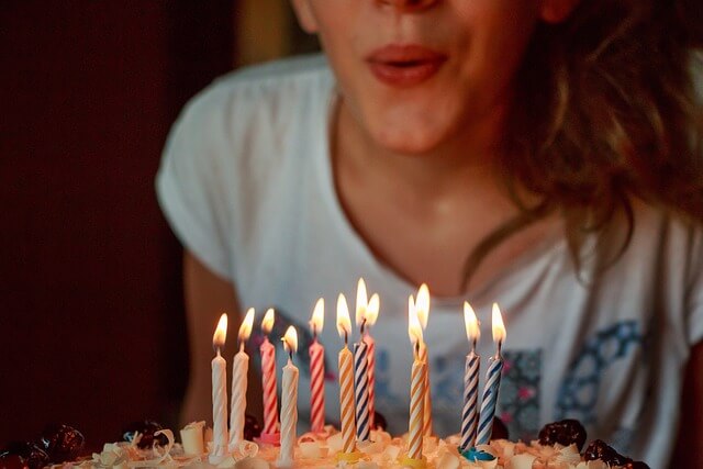 생일 케이크 촛불 부는 여성
