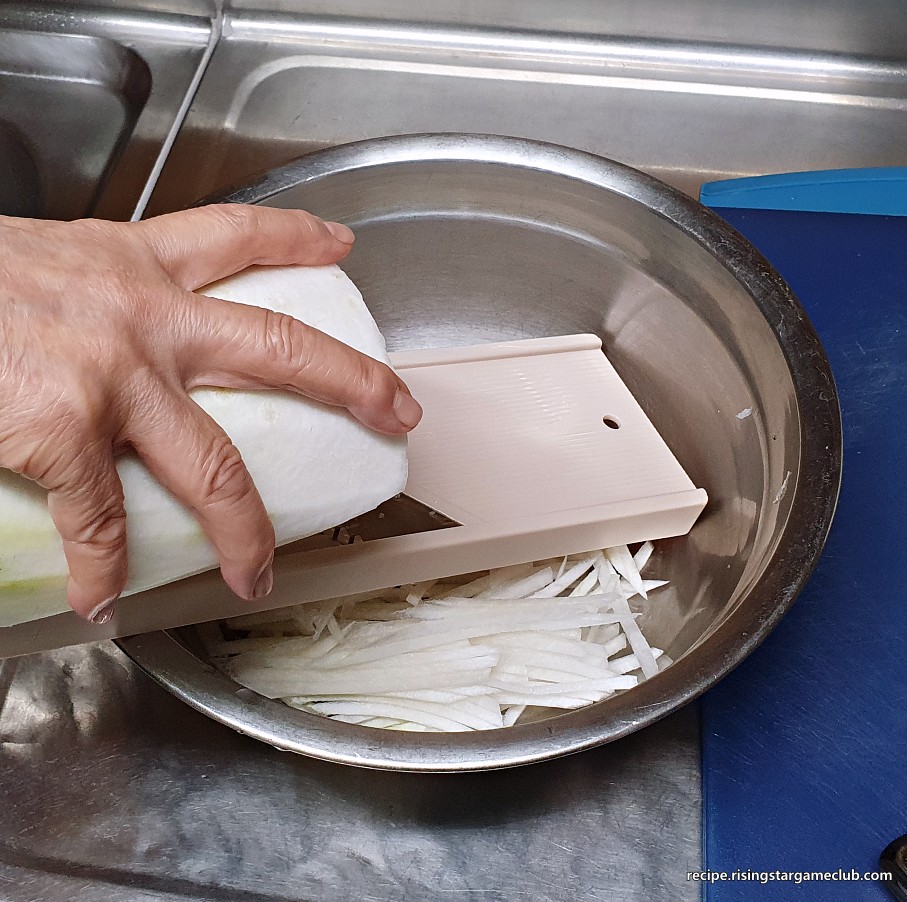 무생채 무침에 들어갈 무를 채칼로 채써는 사진