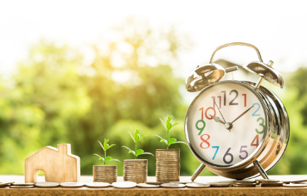 시간과 금융 성장을 나타내는 시계와 동전 더미