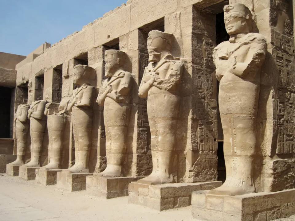 람세스 3세 신전의 벽면에 따라 나란히 세워진 여러 파라오 석상들. 각 조각상은 팔을 가슴에 모은 자세로 서 있다.