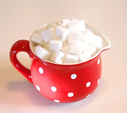 붉은색 머그컵에 하얀 각설탕들이 수북하게 담겨있다.