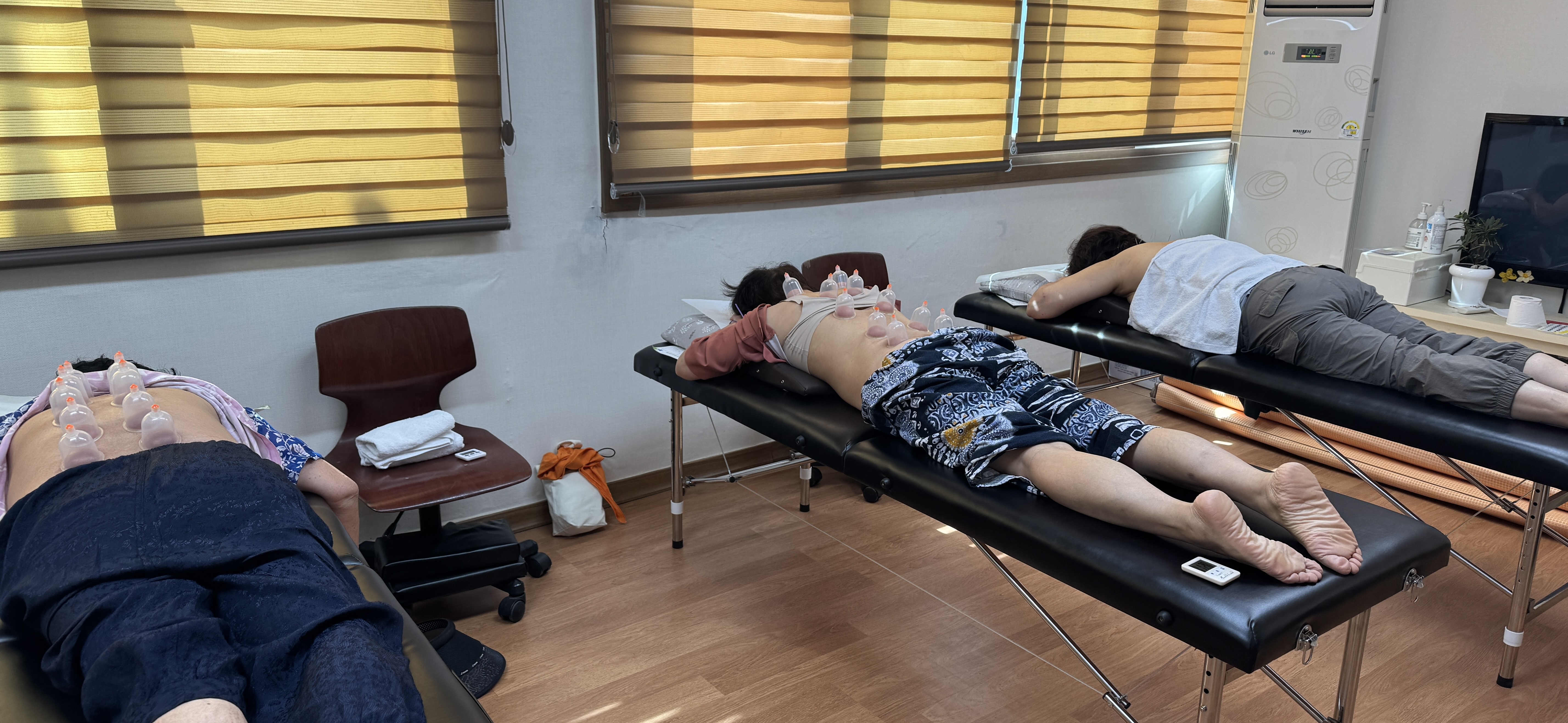 어르신 세 분이 나란히 누워 건부황 치료를 받는 모습