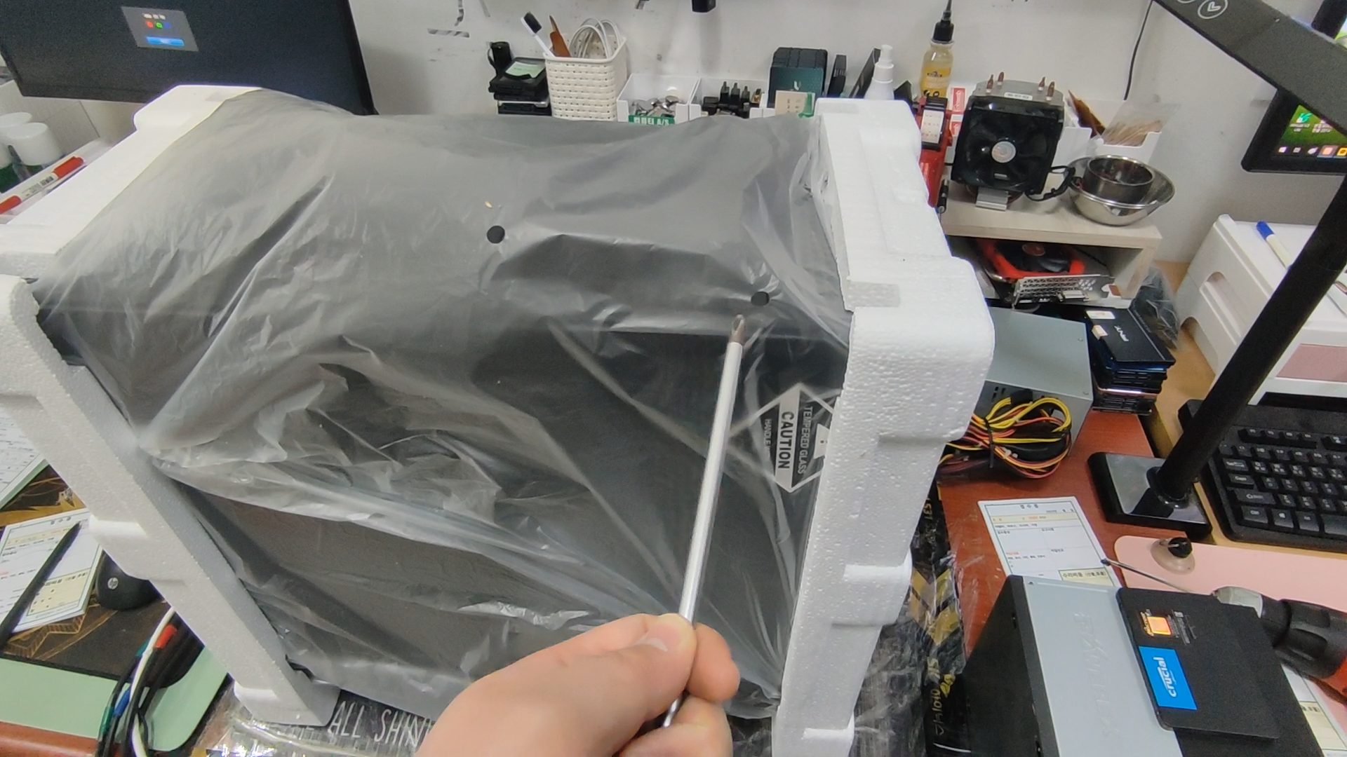 십자 드라이버를 손바닥으로 감싸고 컴퓨터 케이스의 정전기를 방전 시키는 중