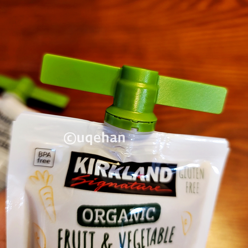 커클랜드 시그니춰 유기농 프루트 앤 베제터블 파우치 위에 프로펠러처럼 생긴 연두색 뚜껑이 달려있다.