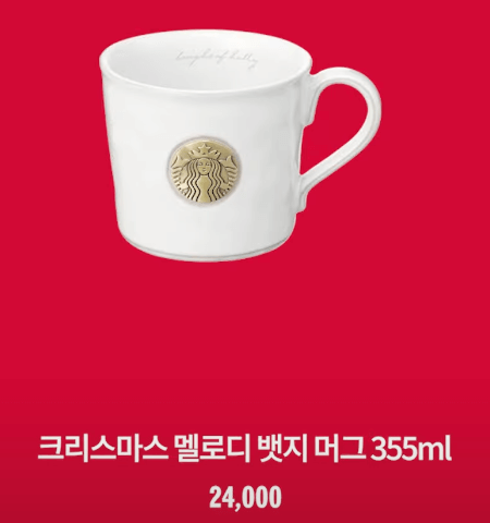 흰색 머그컵 가운데 금색 스타벅스 로고가 있습니다.