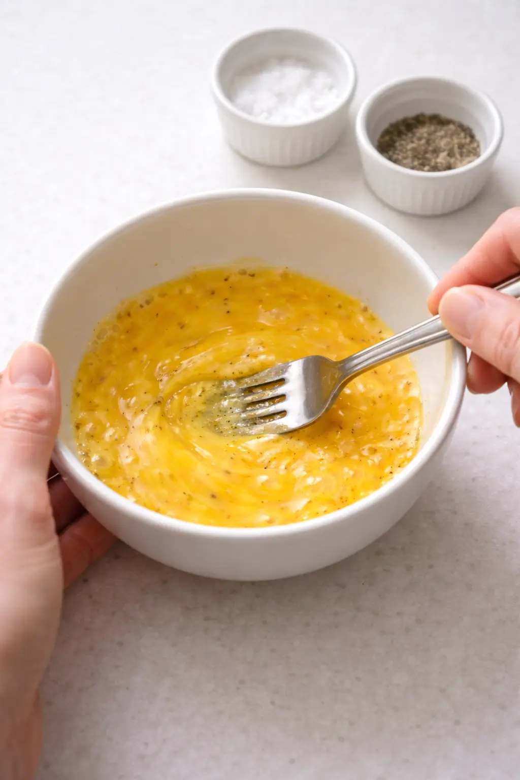 볼에 계란을 풀고 소금과 후추를 넣어 계란물을 만드는 모습