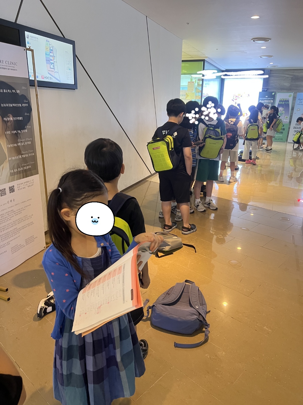 영어학원 입장 전 줄을 기다리며 단어장을 복습하는 7살 아이