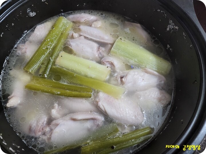 냄비에 닭 봉과 닭 날개, 대파를 넣고 끓이는 모습
