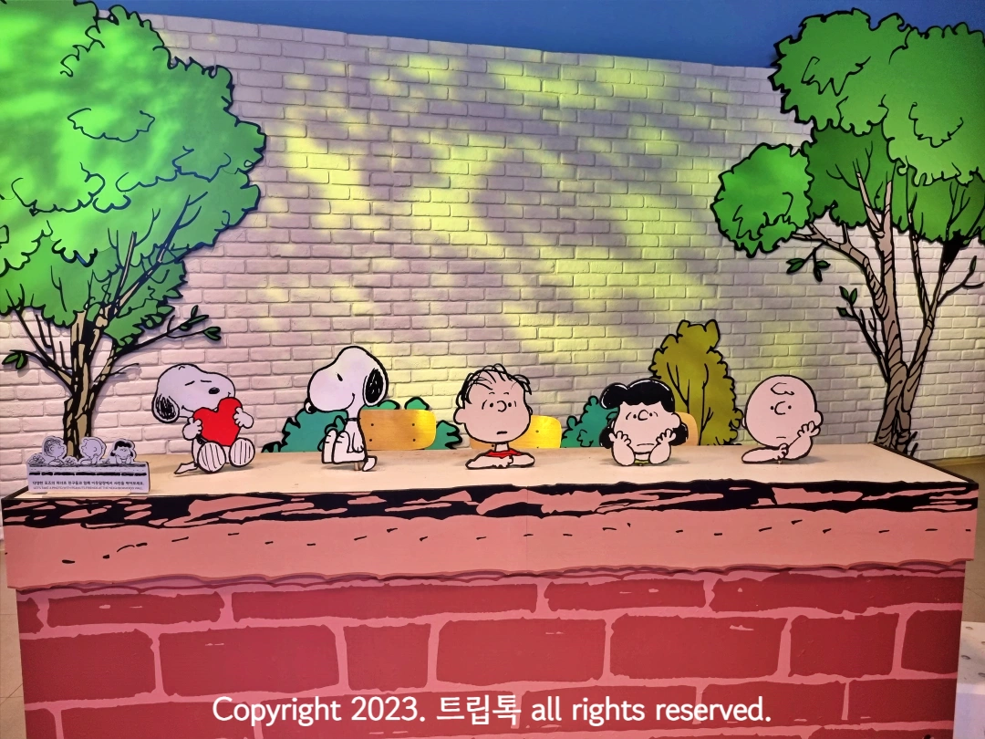 스누피와 찰리 등 캐릭터가 벽위에 앉아있다.
