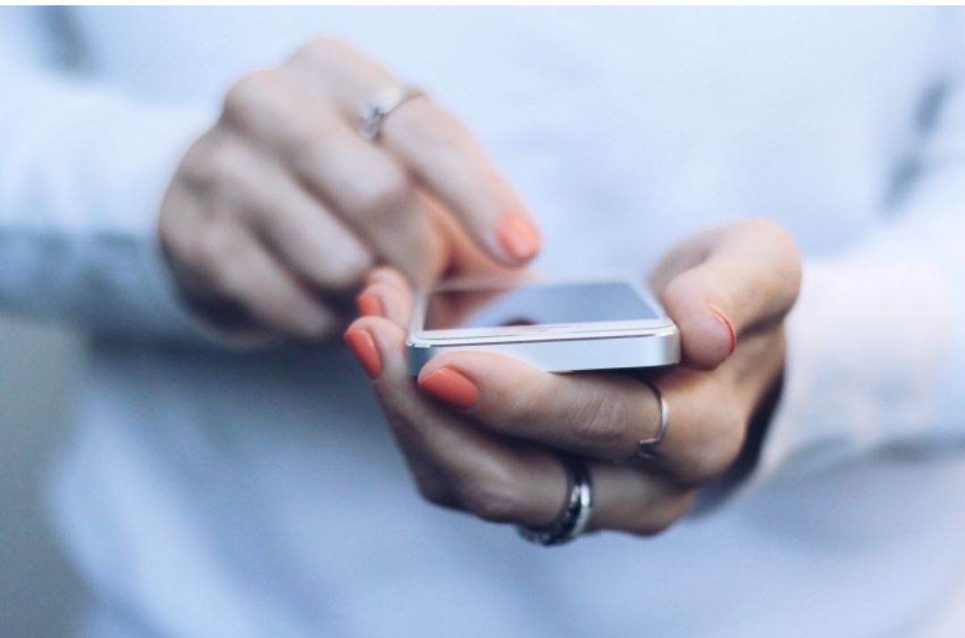 한 여성이 스마트폰을 다루고 있다.