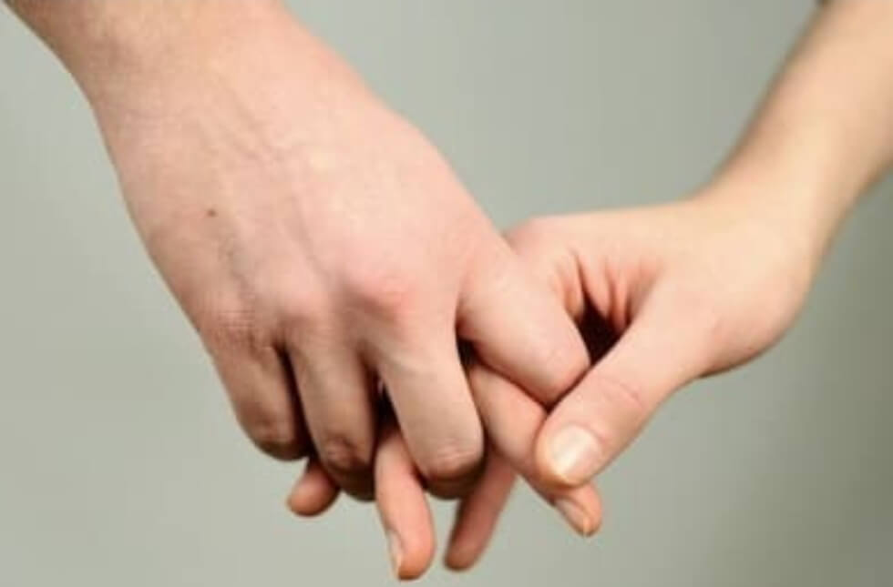 남자와 여자가 손가락 깍지를 끼고 있다