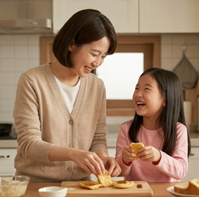 엄마와 딸이 나란히 앉아 간식을 만들며 웃는 장면