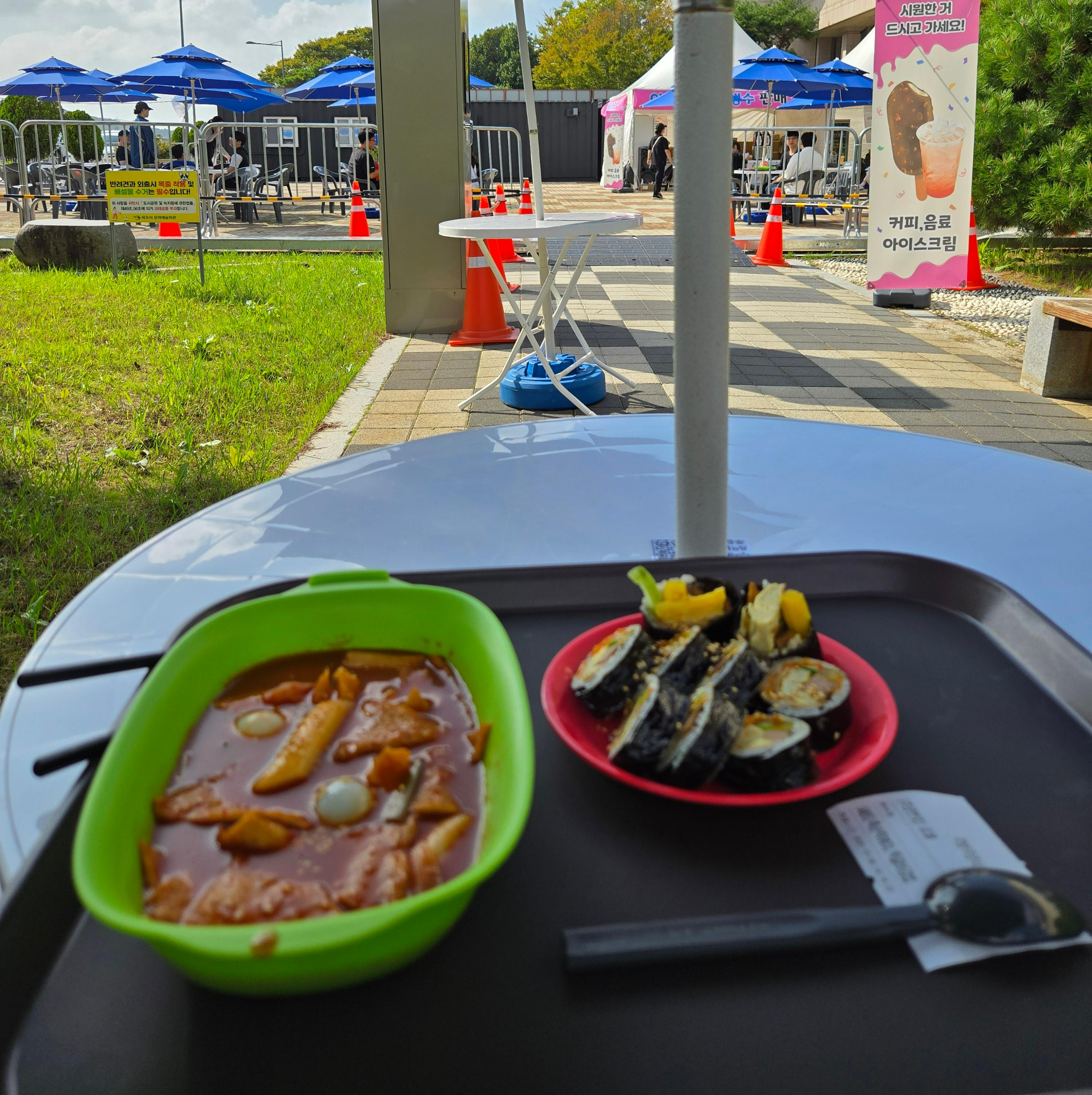 남도국제미식산업박람회 미식로드존에서 맛본 김밥과 떡볶이, 야외 테이블에 놓인 간단한 식사 모습