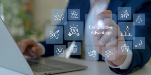 한 비즈니스맨이 '경쟁 우위'라고 쓰인 가상 스크린의 아이콘을 터치하는 모습