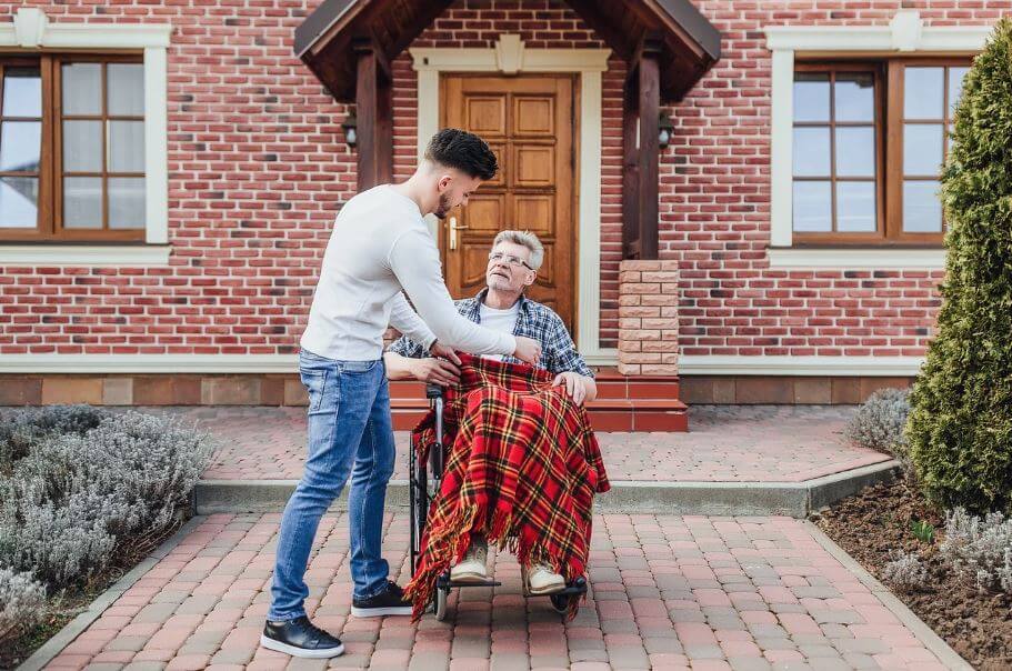 휠체어를 탄 아버지를 케어하는 아들