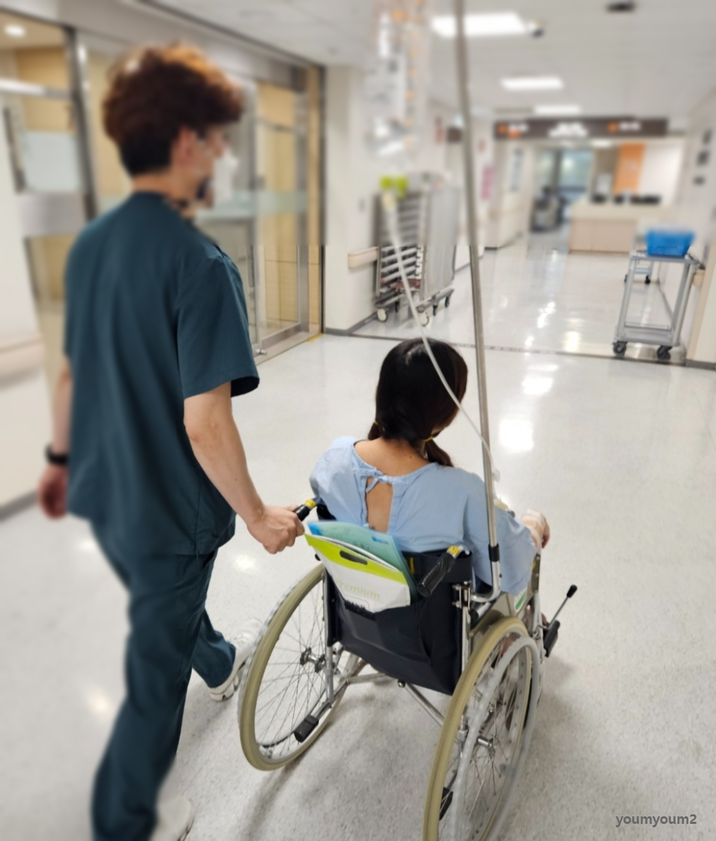 환자복을 입고 휠체어에 앉아 수술실로 이동하는 망막박리 환자의 모습