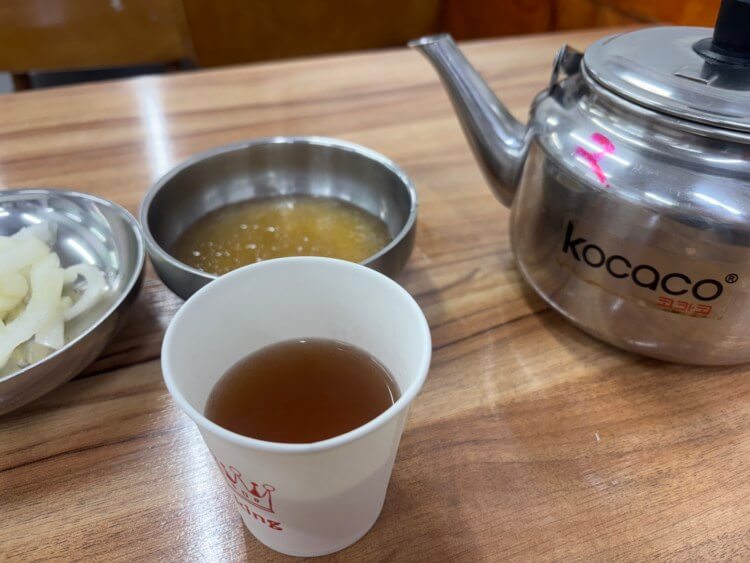 육수가 담긴 주전자와 종이컵 사진이다.