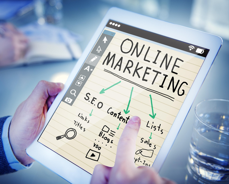 한 사람이 태블릿을 들고 있고 테블릿 화면에는 온라인 마케팅이라고 적혀있다.