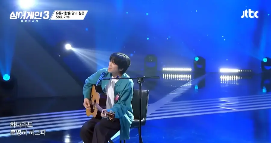 싱어게인3-
초록색 남방에 안쪽 흰색 면티를 입고 갈색 기타를 치며 검정색 바지을 입은채 검정색 의자에 앉아 가슴에 58 번호표를 달고 스탠딩마이크에 입을 대고 노래하는 58호